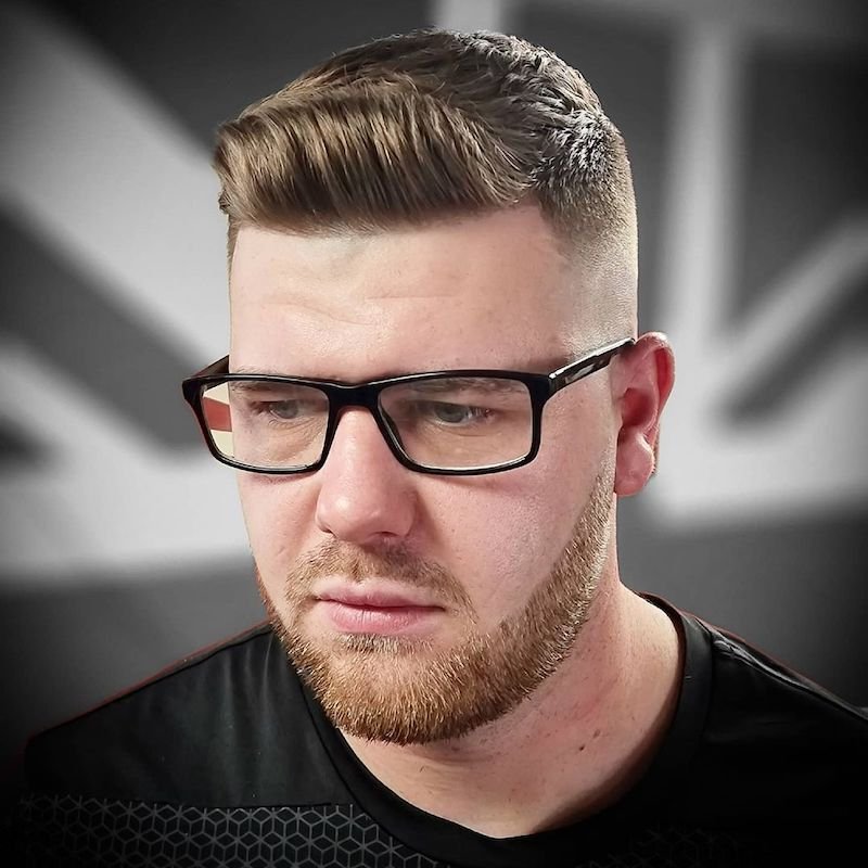 رجل بشعر أشقر مصفف بأسلوب "كويف" (quiff) المرتفع من الأمام والمستوحى من الخمسينيات