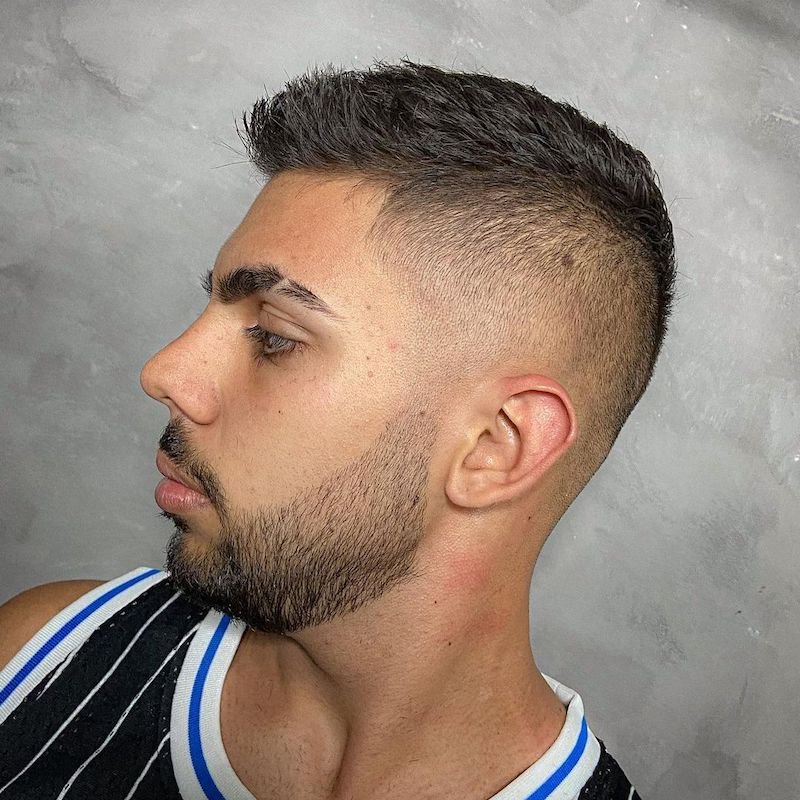 رجل بتسريحة شعر قصيرة جداً (crew cut) مع جوانب متدرجة الطول (faded sides) مستوحاة من الخمسينيات