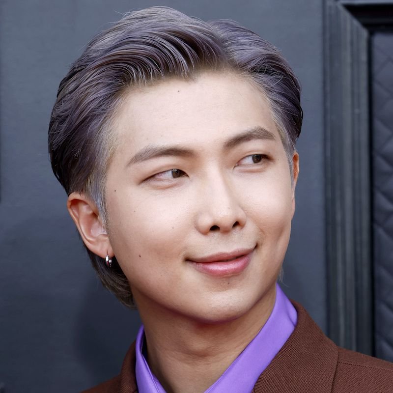 آر إم (RM) من فرقة BTS بتسريحة شعر مصففة للخلف بلون رمادي مائل للأرجواني ومستوحاة من الخمسينيات