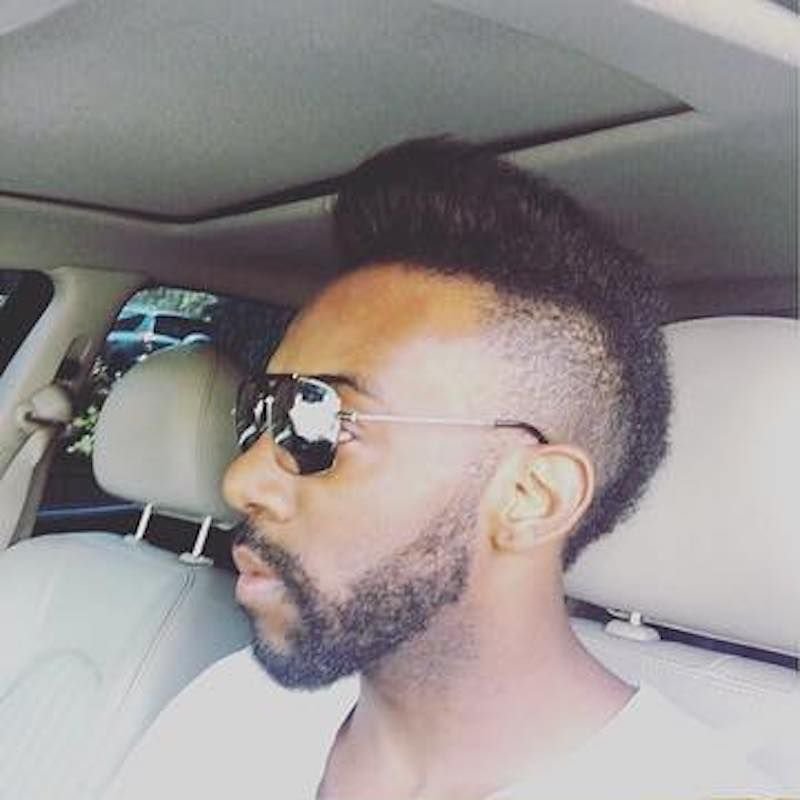 لقطة جانبية لتسريحة "بومبادور" (Pompadour) الطبيعية بأسلوب الخمسينيات، مع جوانب متدرجة (Faded) ولحية