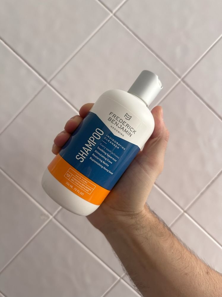 Close-up of a hand holding a bottle of Frederick Benjamin Shampoo