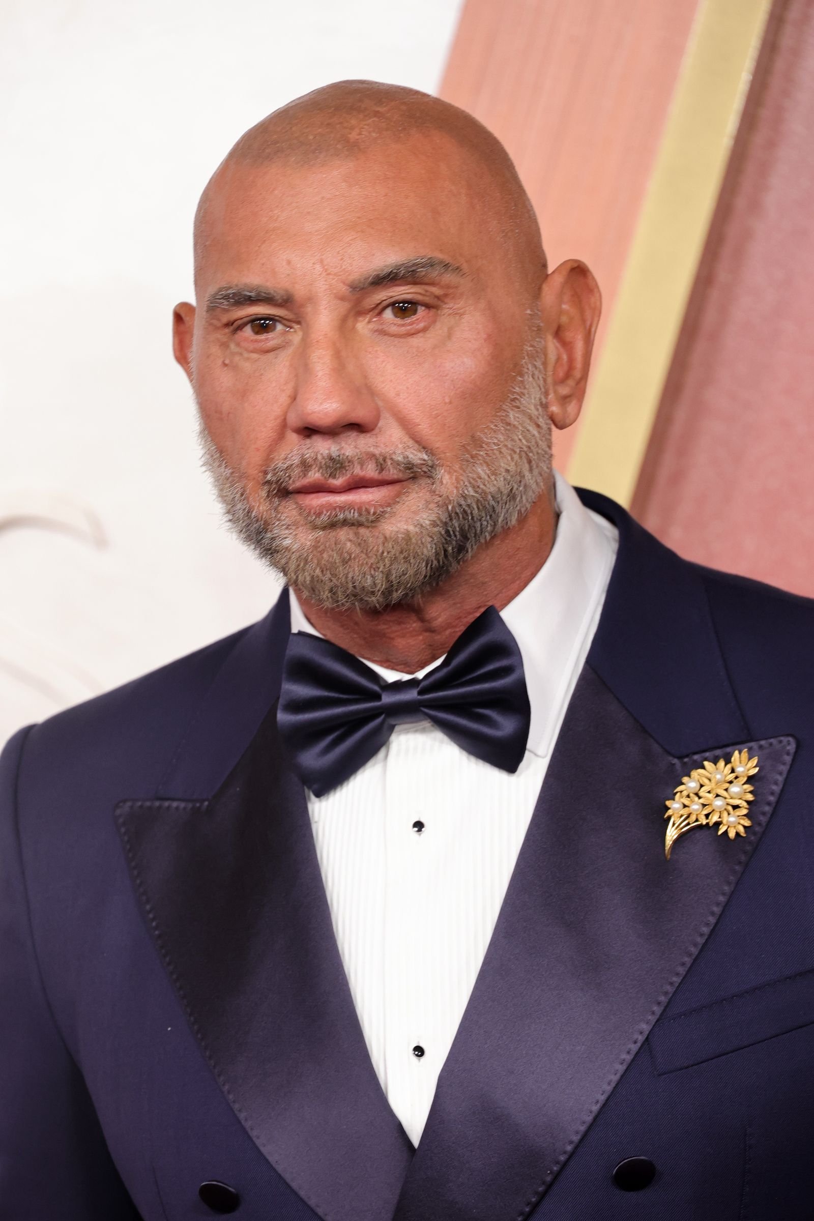 ربما تحتوي الصورة على إكسسوارات Dave Bautista ملابس رسمية وربطة عنق وبدلة وجه ورأس وشخص وتصوير فوتوغرافي