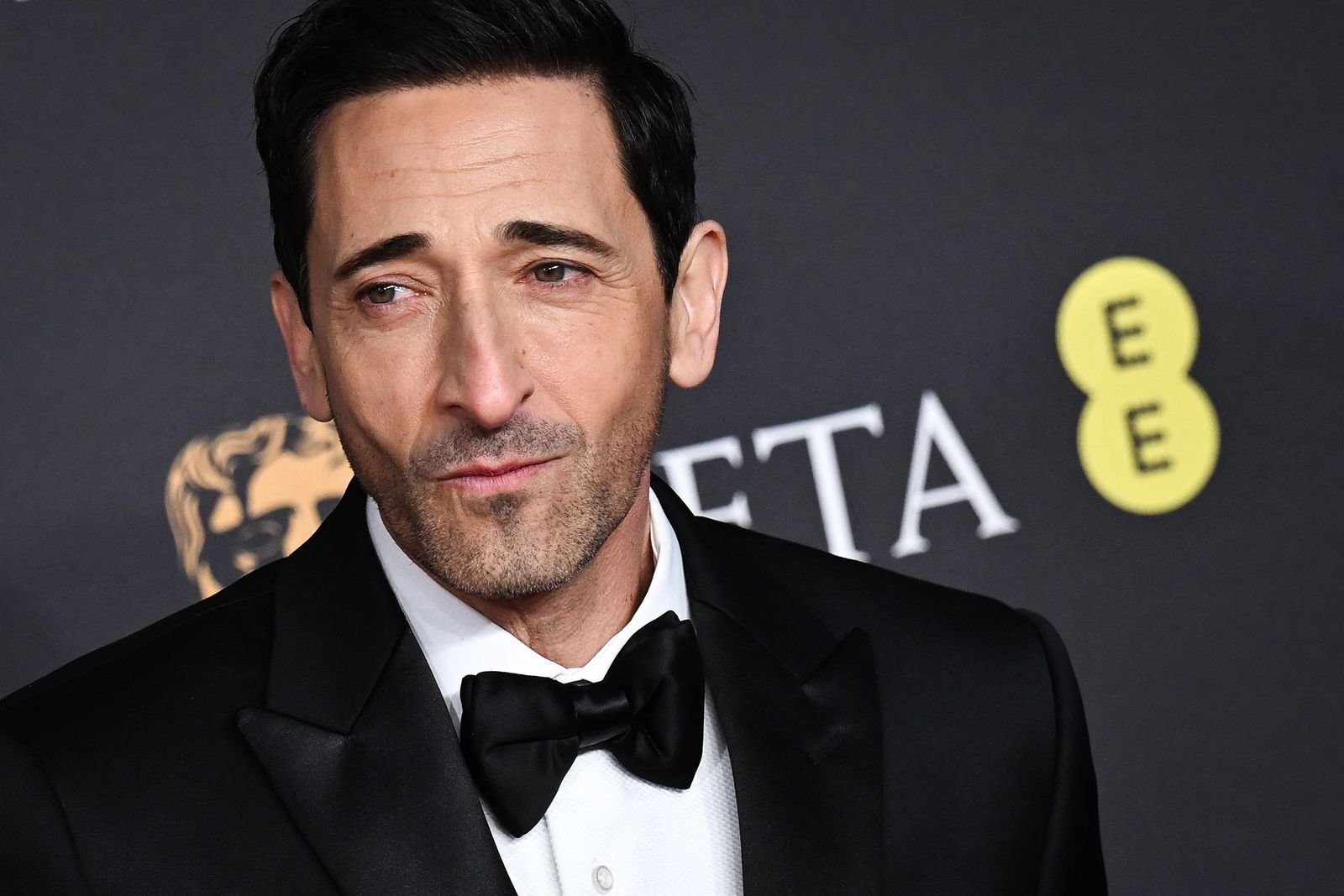 ربما تحتوي الصورة على إكسسوارات Adrien Brody، ملابس رسمية، ربطة عنق، بدلة شخص بالغ، وجه، رأس وتصوير فوتوغرافي