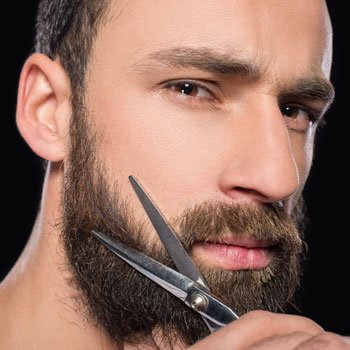 رجل يقوم بتشذيب لحيته بالمقص في أكتوبر